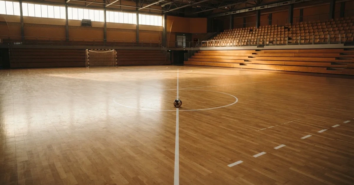Un balón en el punto central de un campo de césped a la luz de la mañana